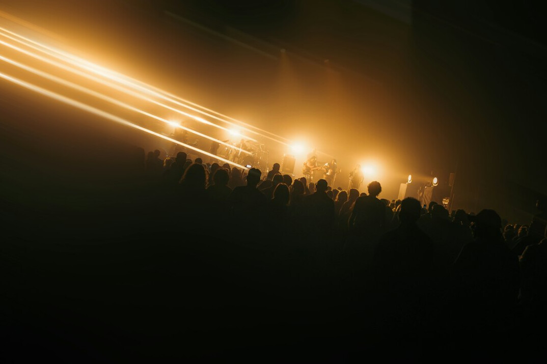 Blurred crowd with warm stage light in the distance